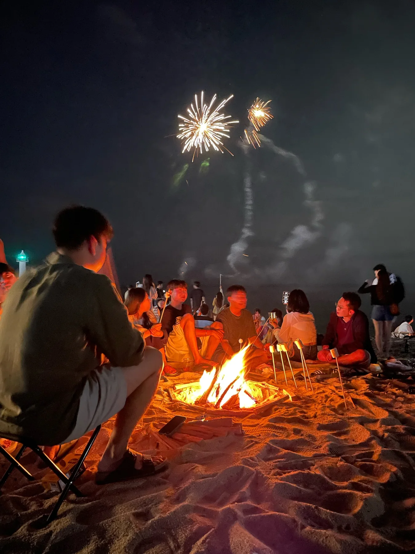 해변 불 앞에서 어울리는 참가자들