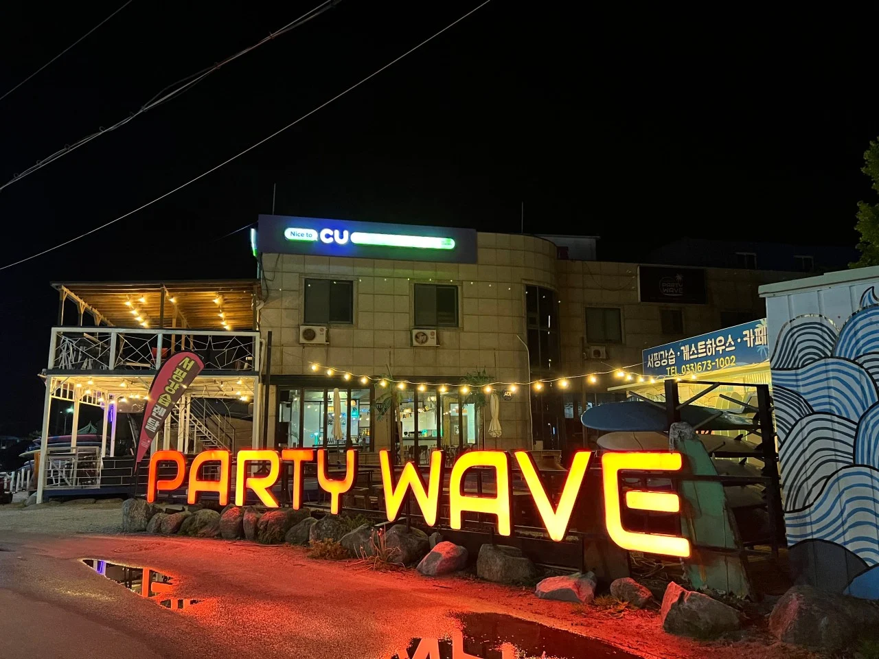 붉은 조명이 켜진 PARTY WAVE 야간 외관