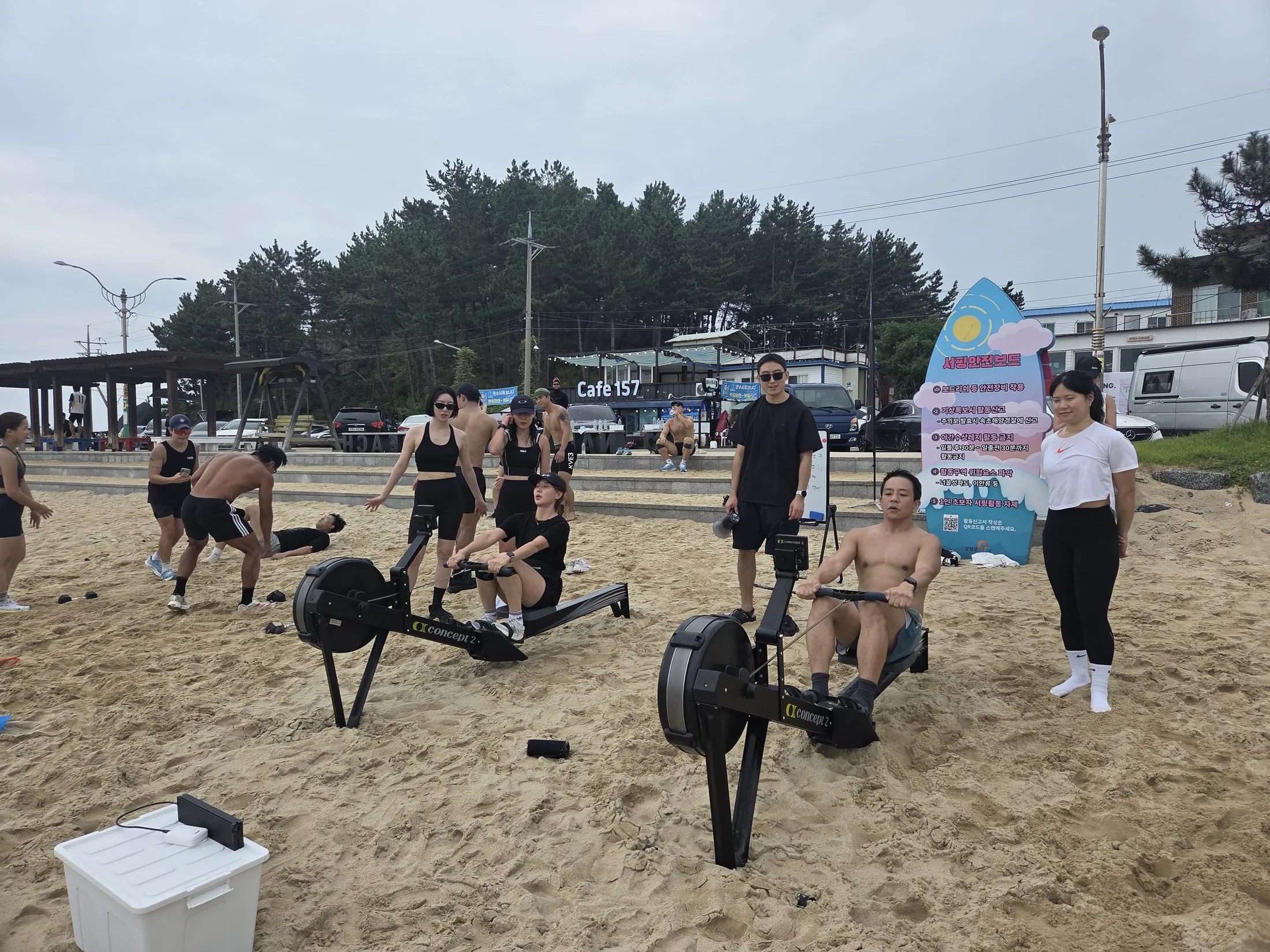 해변 로잉 구간에서 운동하는 두 참가자와 운영진